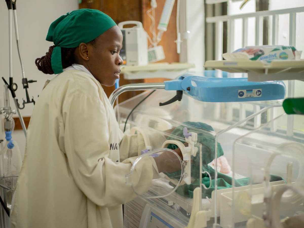 A nurse tending to incubators in a hospital maternity unit